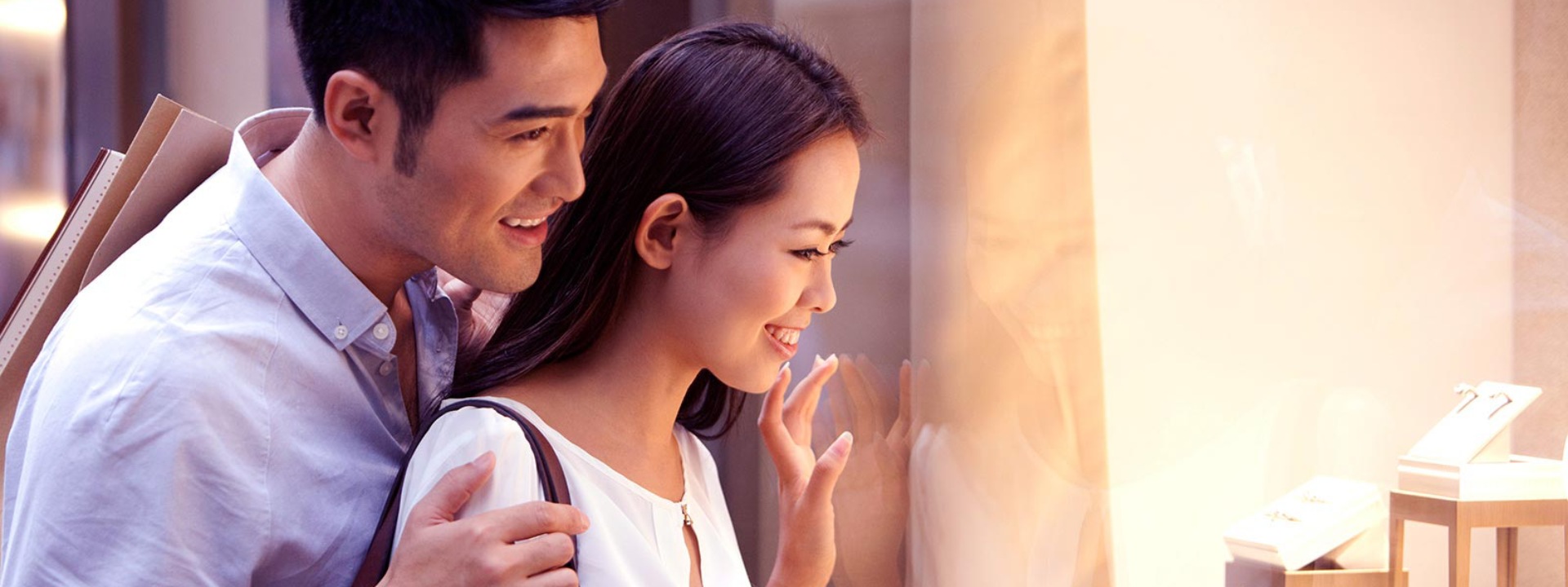 a couple looks at jewelry in a shop window