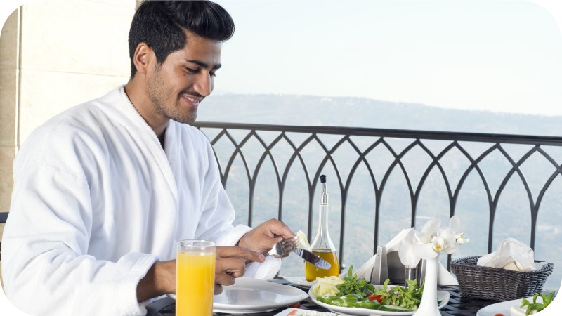A man dining on the balcony of a luxury hotel